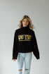 Woman wearing a black sweater with 'APP STATE' text on a plain background