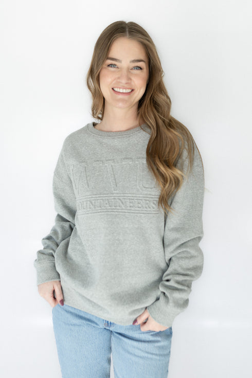 Woman wearing a gray sweatshirt with text on a white background