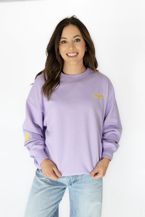 Woman wearing a purple sweatshirt with a logo on a white background