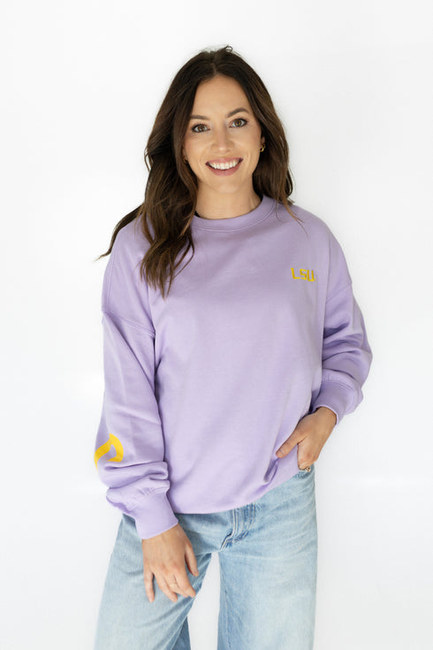Woman wearing a purple sweatshirt with yellow accents on a white background