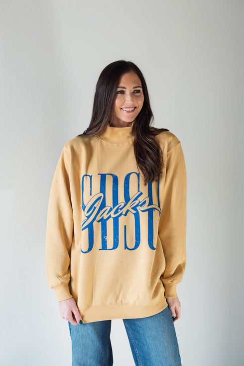 Woman wearing a beige sweatshirt with blue text on a plain background