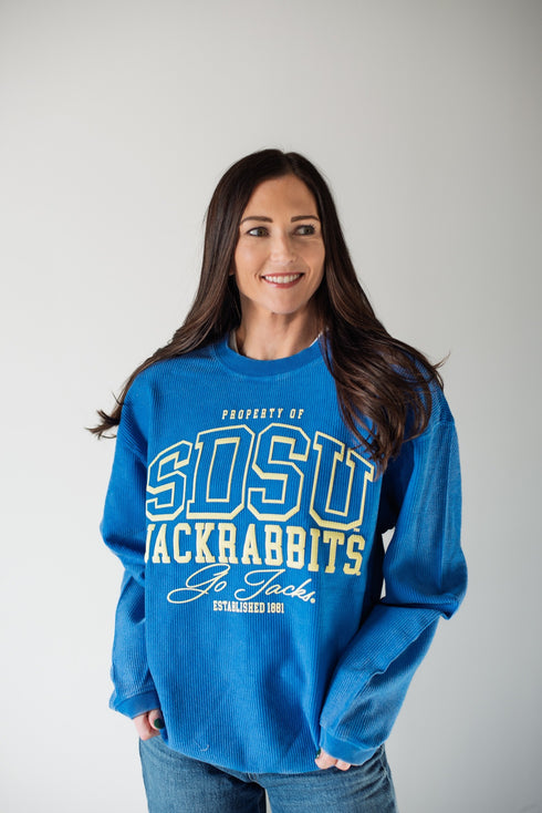 Woman wearing a blue sweatshirt with 'SDSU Jackrabbits' text on a plain background